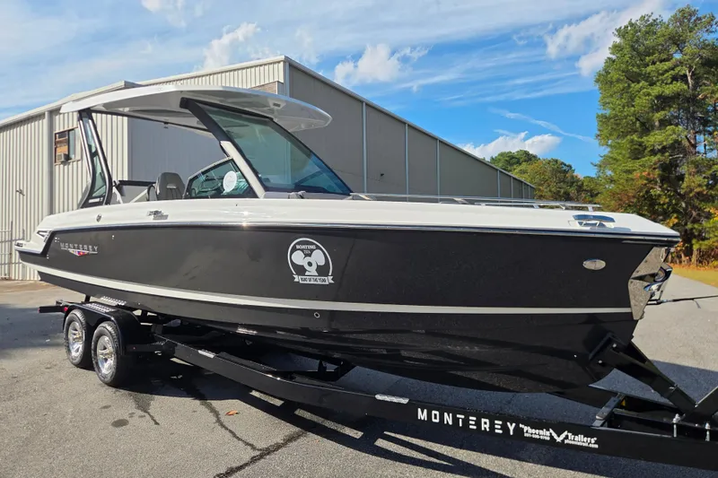 Slide: The Image of 2026 Monterey Elite 27 SD boat on trailer, parked outdoors with trees in background. - 9