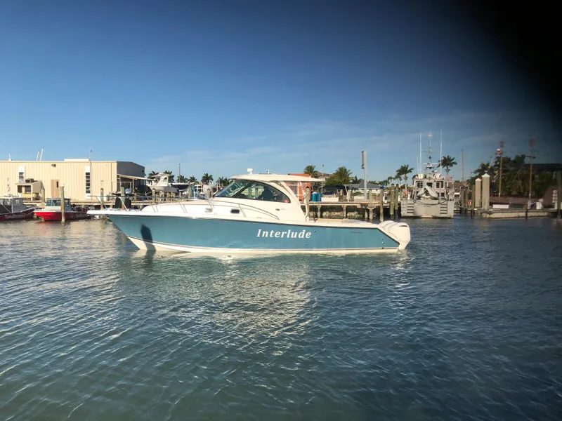 The Image of 2016 Pursuit OS 385 Offshore boat docked in sunny marina. - 0