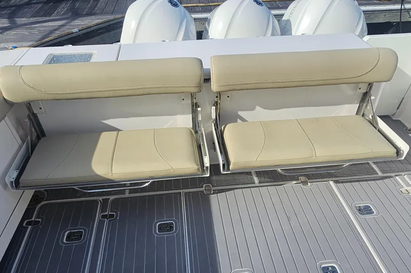 Slide: The Image of 2016 Pursuit OS 385 Offshore boat with foldable beige seats and sleek deck design. - 25