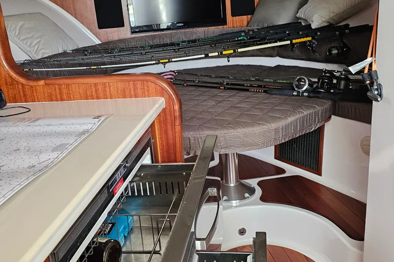 Slide: The Image of 2016 Pursuit OS 385 Offshore cabin interior with fishing rods and open drawer. - 5