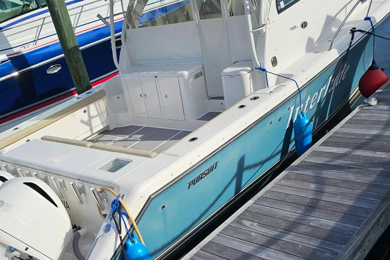 Slide: The Image of 2016 Pursuit OS 385 Offshore boat docked, featuring spacious deck and sleek design. - 6