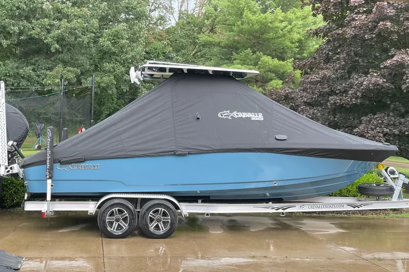 Slide: The Image of 2022 Crevalle 26 HCO boat covered on trailer, parked outdoors. - 3