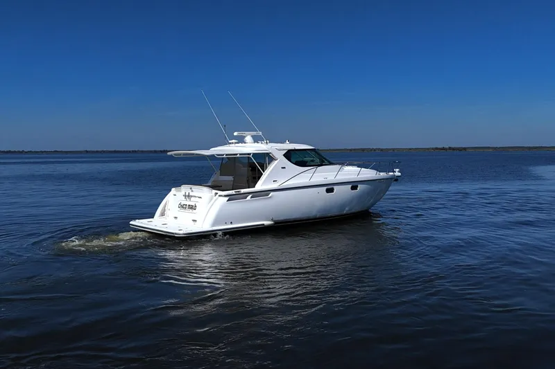 Slide: The Image of 2008 Tiara Yachts 4300 Sovran cruising on open water under clear blue sky. - 4