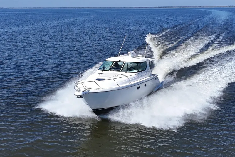 Slide: The Image of 2008 Tiara Yachts 4300 Sovran cruising on open water, creating a dynamic wake. - 67