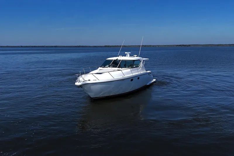 Slide: The Image of 2008 Tiara Yachts 4300 Sovran cruising on open water under clear blue skies. - 8