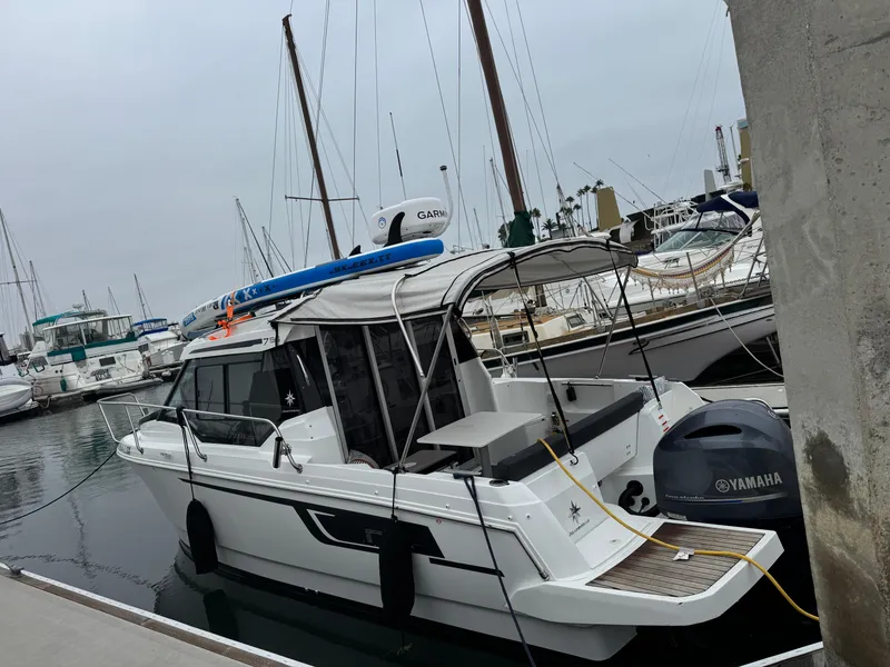 Slide: The Image of 2020 Jeanneau NC 795 boat docked in marina, rear view with outboard motor. - 5