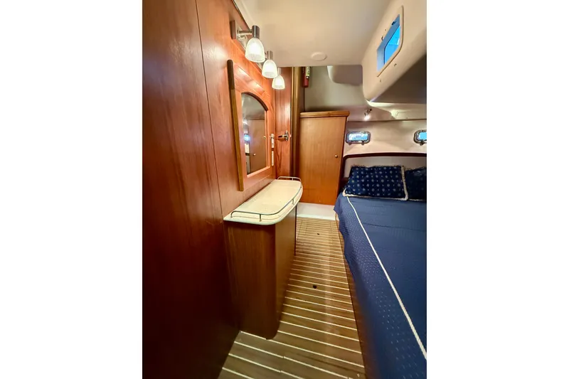 Slide: The Image of Interior of 2003 Hunter 426 Deck Salon with wood paneling and blue bedding. - 15