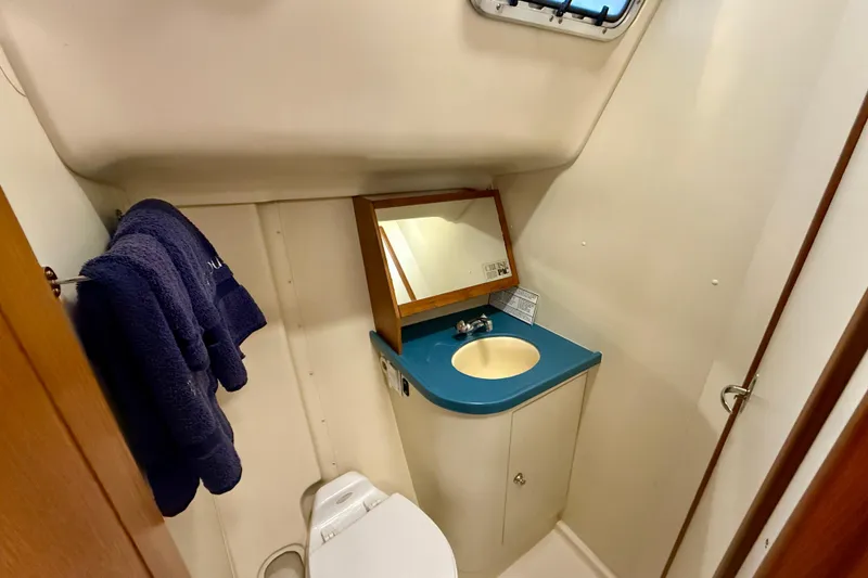 Slide: The Image of Compact bathroom in 2003 Hunter 426 Deck Salon yacht with sink, mirror, and towel. - 19