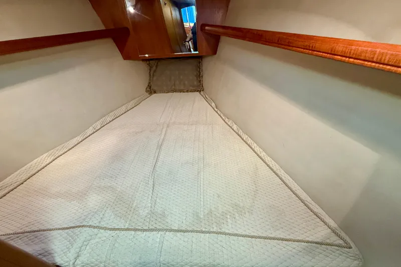 Slide: The Image of 2003 Hunter 426 Deck Salon interior cabin with cozy bedding and wooden accents. - 20