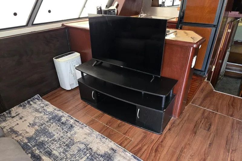 Slide: The Image of Interior of 1987 Bayliner 4550 Motoryacht with TV, wooden flooring, and modern furnishings. - 15
