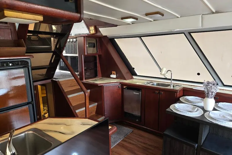 Slide: The Image of Interior of 1987 Bayliner 4550 Motoryacht with kitchen, dining area, and wooden stairs. - 16