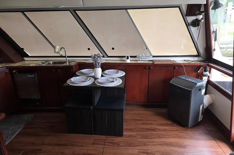 Slide: The Image of Interior of 1987 Bayliner 4550 Motoryacht with dining setup and kitchen area. - 17