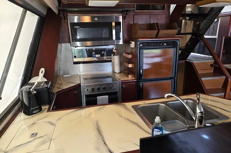 Slide: The Image of 1987 Bayliner 4550 Motoryacht kitchen with modern appliances and marble countertop. - 19
