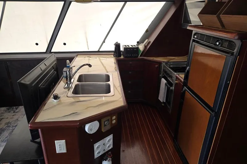 Slide: The Image of 1987 Bayliner 4550 Motoryacht kitchen with dual sinks, stove, and refrigerator. - 20