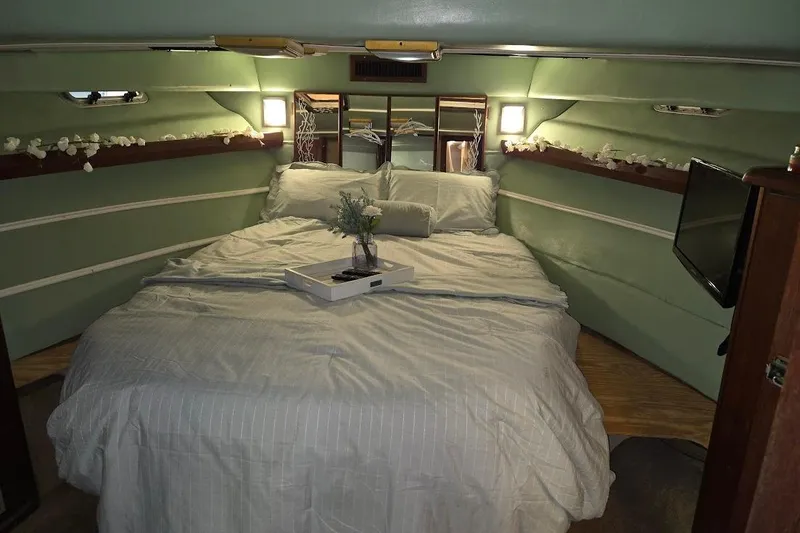 Slide: The Image of Cozy bedroom interior of 1987 Bayliner 4550 Motoryacht with elegant decor and soft lighting. - 25