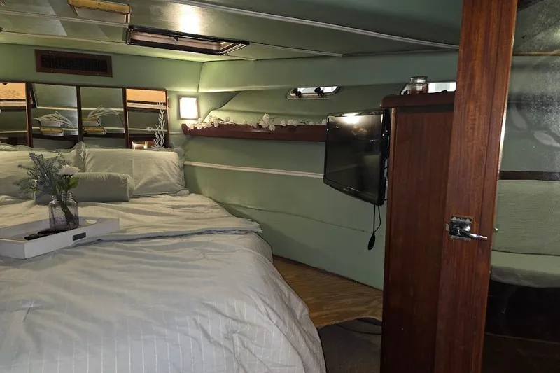 Slide: The Image of Cozy bedroom interior of 1987 Bayliner 4550 Motoryacht with bed, TV, and decor. - 26