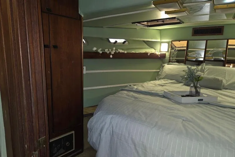 Slide: The Image of Cozy bedroom interior of 1987 Bayliner 4550 Motoryacht with wood accents and soft lighting. - 27