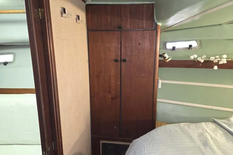 Slide: The Image of Interior of 1987 Bayliner 4550 Motoryacht with wooden closet and cozy decor. - 29