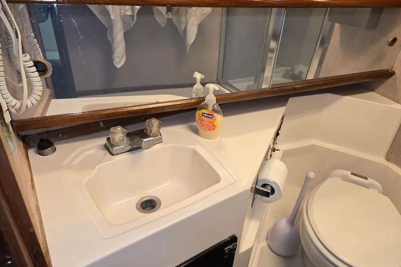 Slide: The Image of Bathroom interior of 1987 Bayliner 4550 Motoryacht with sink, mirror, and toilet. - 31