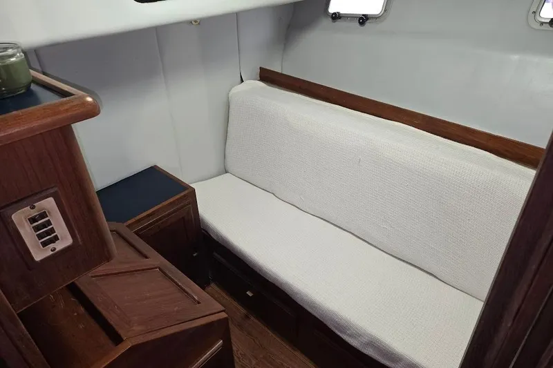 Slide: The Image of 1987 Bayliner 4550 Motoryacht interior with white cushioned seating and wooden accents. - 33