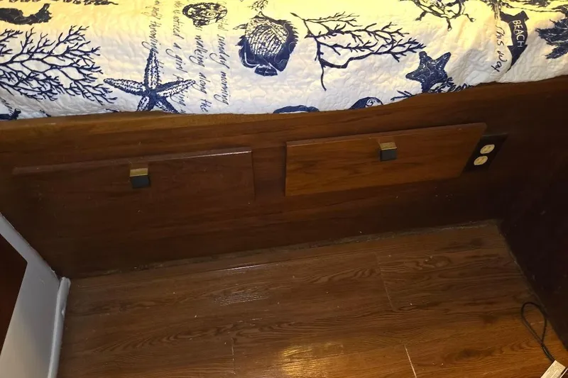 Slide: The Image of 1987 Bayliner 4550 Motoryacht interior with wood paneling and nautical-themed bedding. - 36