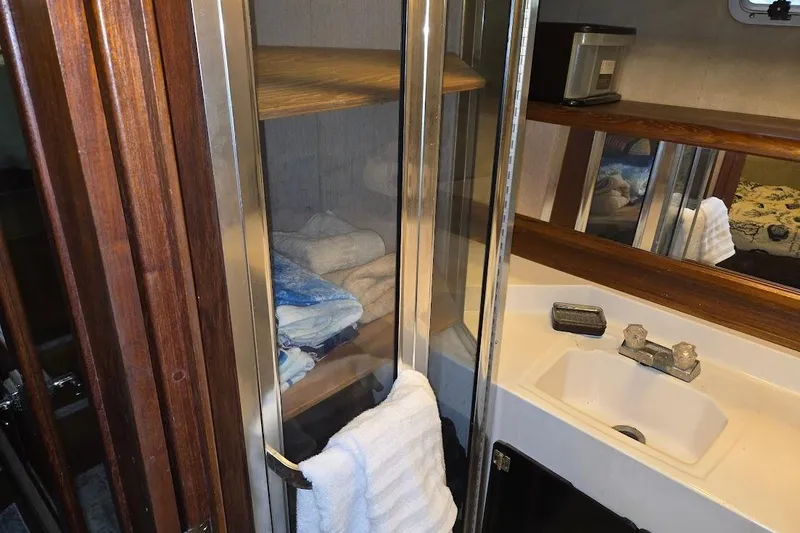 Slide: The Image of 1987 Bayliner 4550 Motoryacht bathroom with sink, mirror, and towel storage. - 41
