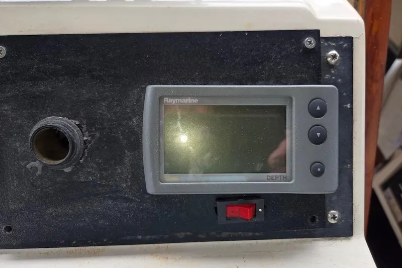 Slide: The Image of Raymarine depth gauge on 1987 Bayliner 4550 Motoryacht dashboard, with adjacent switch and port. - 56