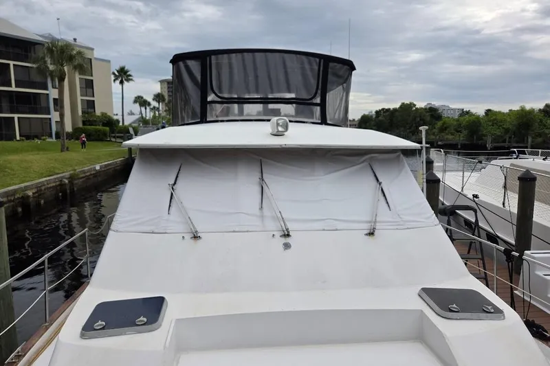 Slide: The Image of 1987 Bayliner 4550 Motoryacht docked, featuring covered deck and marina backdrop. - 70
