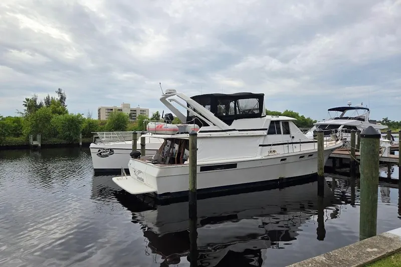Slide: The Image of 1987 Bayliner 4550 Motoryacht docked at a marina under cloudy skies. - 71