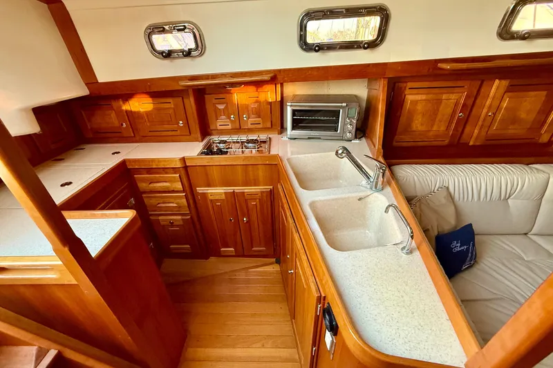 Slide: The Image of Luxurious Tartan 4000 yacht interior with wooden cabinetry, dual sinks, and cozy seating, 2015 model. - 12