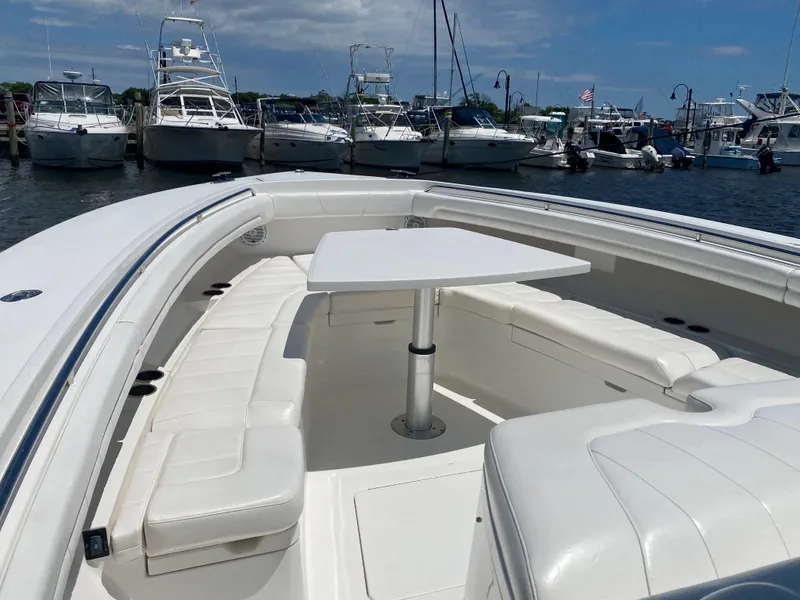 Slide: The Image of 2016 Regulator 41 boat with white seating and table, docked at a marina. - 17