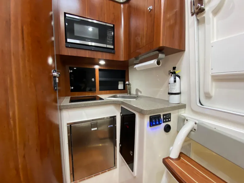 Slide: The Image of 2016 Regulator 41 boat kitchen with microwave, sink, and wooden cabinetry. - 3