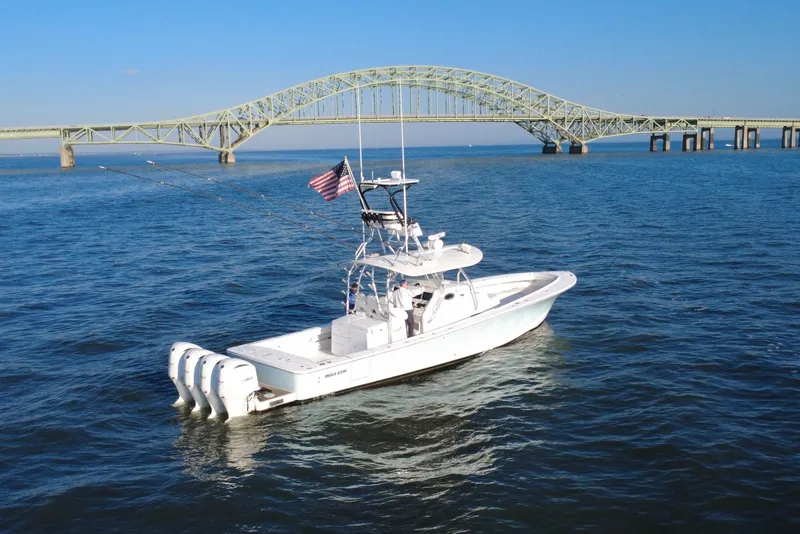 Slide: The Image of 2016 Regulator 41 boat on water near a bridge, with American flag. - 5