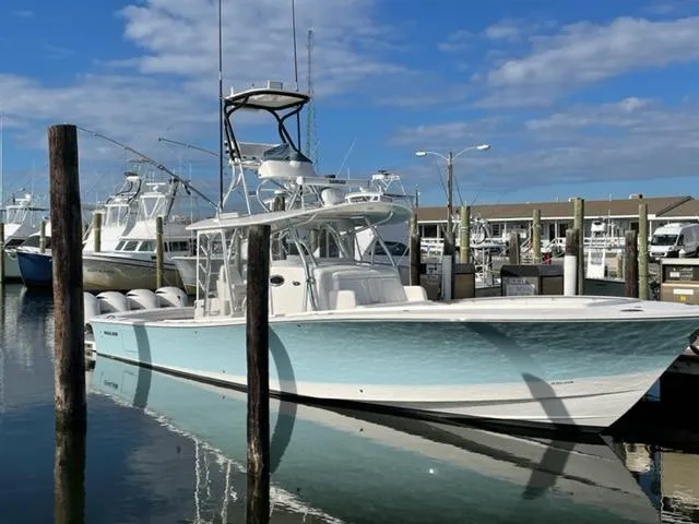 Slide: The Image of 2016 Regulator 41 boat docked in marina, clear sky, calm water reflection. - 6