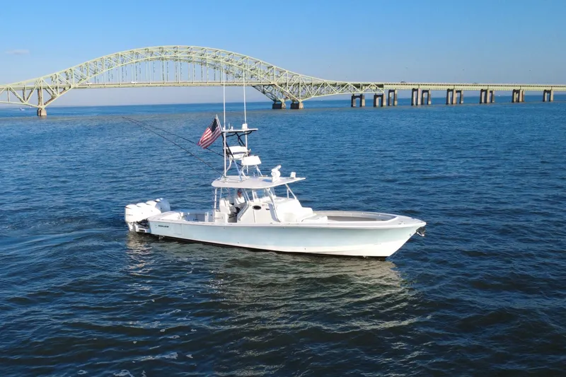 Slide: The Image of 2016 Regulator 41 boat cruising near a bridge on a sunny day. - 69