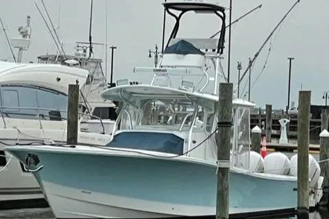 Slide: The Image of 2016 Regulator 41 boat docked in marina, featuring a light blue hull and upper deck. - 7
