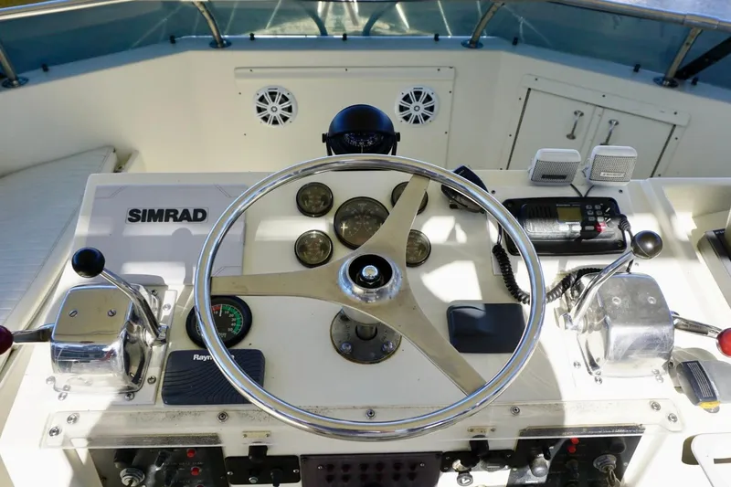 Slide: The Image of Control panel of a 1986 Hatteras 41 Convertible boat with steering wheel and navigation equipment. - 12