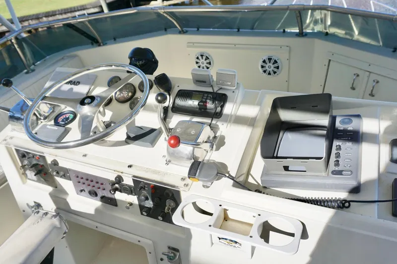 Slide: The Image of 1986 Hatteras 41 Convertible boat helm with steering wheel and navigation controls. - 13