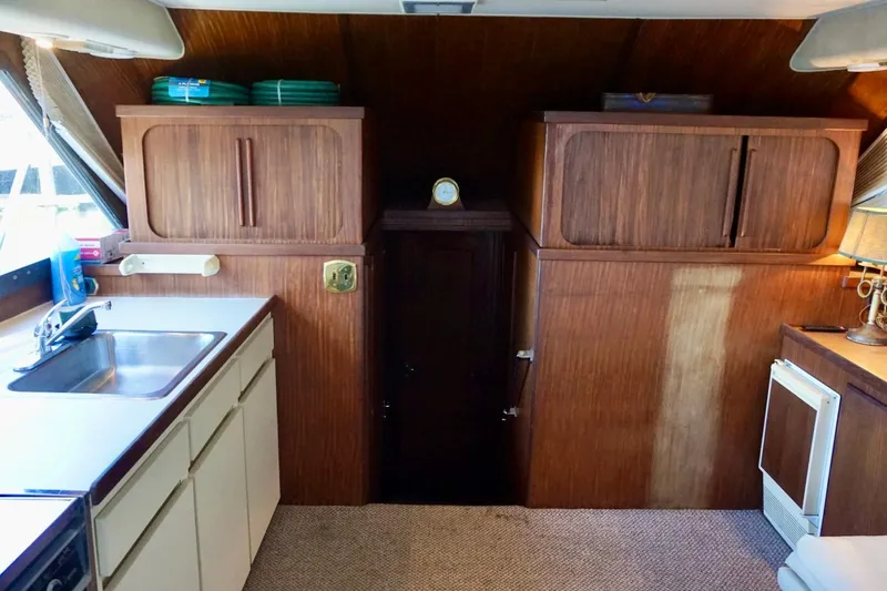 Slide: The Image of Interior of 1986 Hatteras 41 Convertible yacht with wooden cabinets and kitchenette. - 23