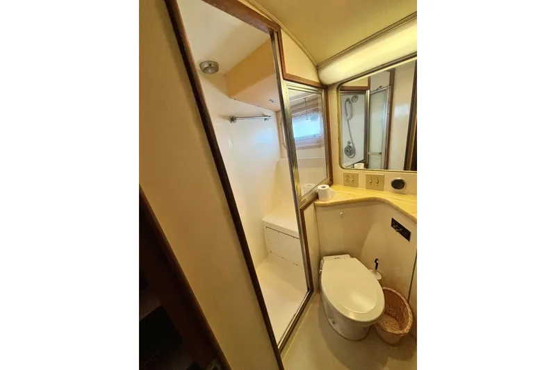 Slide: The Image of 1986 Hatteras 41 Convertible yacht bathroom with shower, toilet, and mirrored vanity. - 30