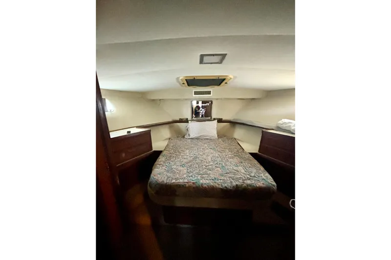 Slide: The Image of Cozy cabin interior of 1986 Hatteras 41 Convertible yacht with bed and wooden accents. - 33