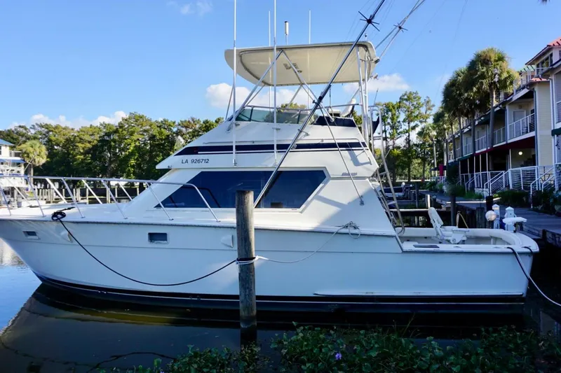 Slide: The Image of 1986 Hatteras 41 Convertible yacht docked by waterfront homes. - 5