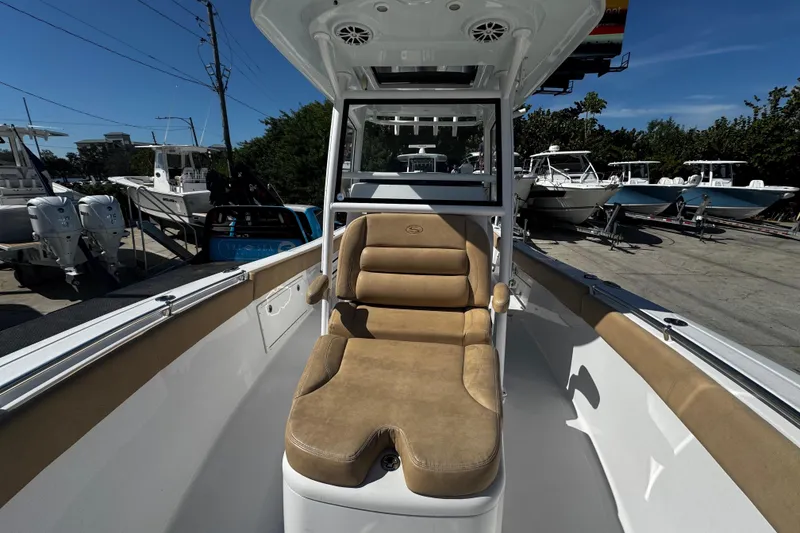 Slide: The Image of 2018 Sportsman Open 282TE Center Console boat with tan seating, docked outdoors. - 11