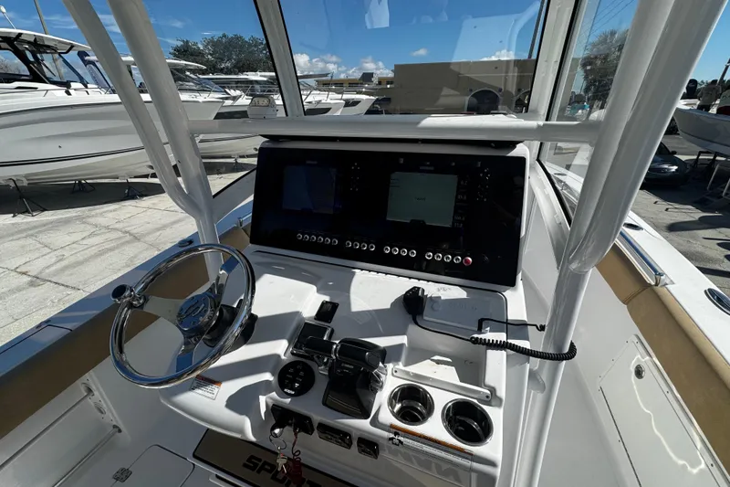 Slide: The Image of 2018 Sportsman Open 282TE Center Console boat dashboard with steering wheel and navigation controls. - 12