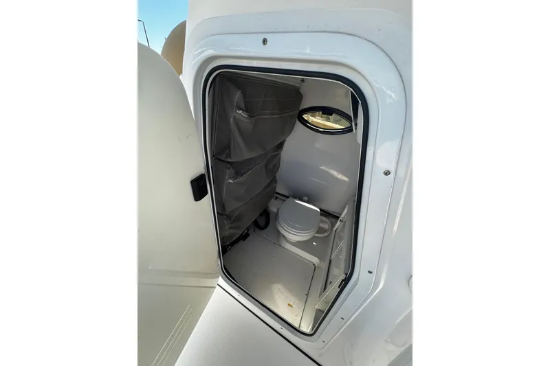 Slide: The Image of 2018 Sportsman Open 282TE Center Console boat interior with compact restroom. - 16