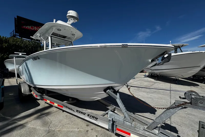 Slide: The Image of 2018 Sportsman Open 282TE Center Console boat on trailer under clear blue sky. - 4