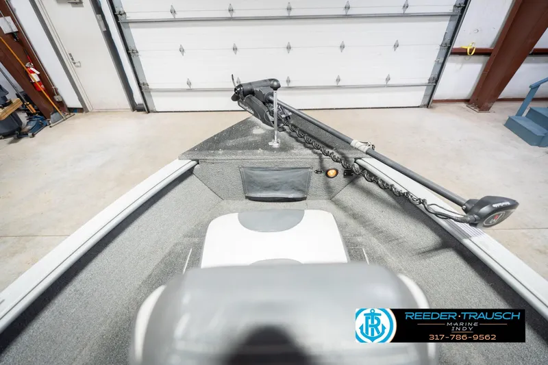 Slide: The Image of 2007 Lund 1600 Explorer SS boat interior in a garage, featuring a trolling motor. - 17