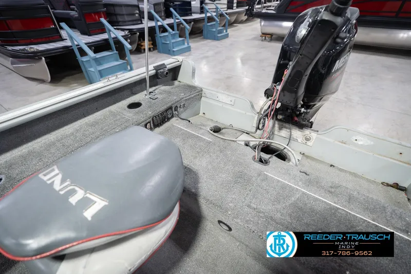 Slide: The Image of 2007 Lund 1600 Explorer SS boat interior with motor and seating, displayed in showroom. - 22