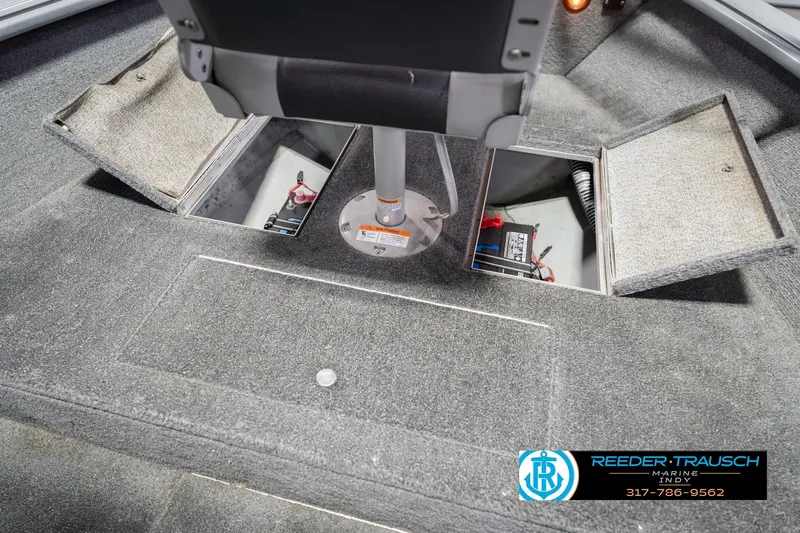 Slide: The Image of 2007 Lund 1600 Explorer SS boat interior with open storage compartments and visible battery. - 28