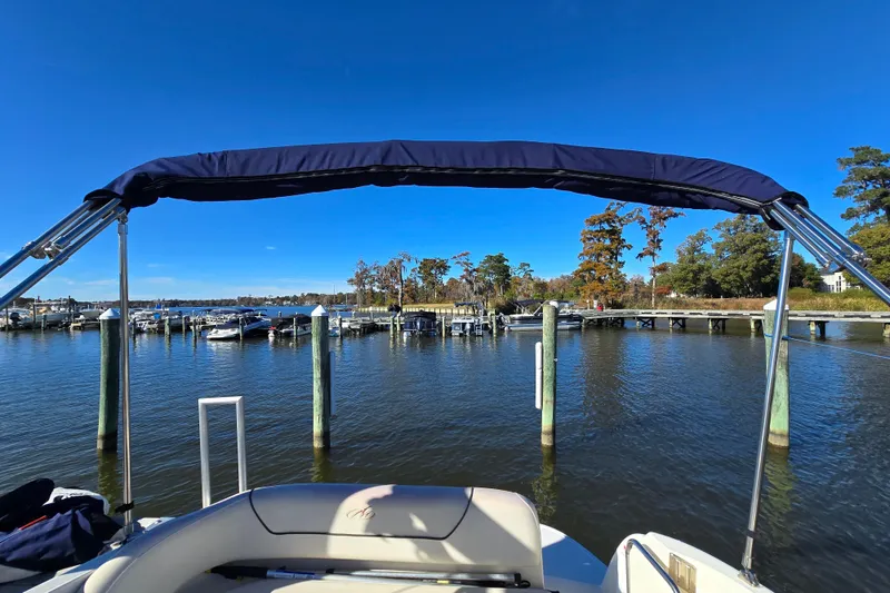 Slide: The Image of 2007 Monterey 250 Cruiser boat docked at a scenic marina under clear blue skies. - 11